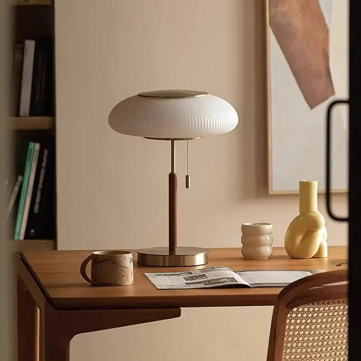 Desk with a lamp, mug, and newspaper in a home office setting