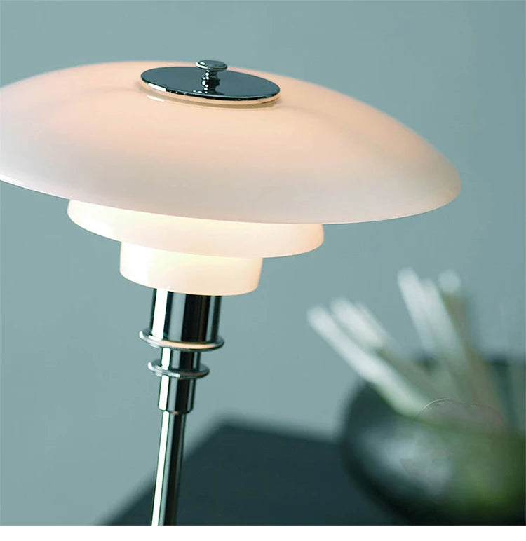 Modern table lamp with a white glass shade and chrome base on a blurred background