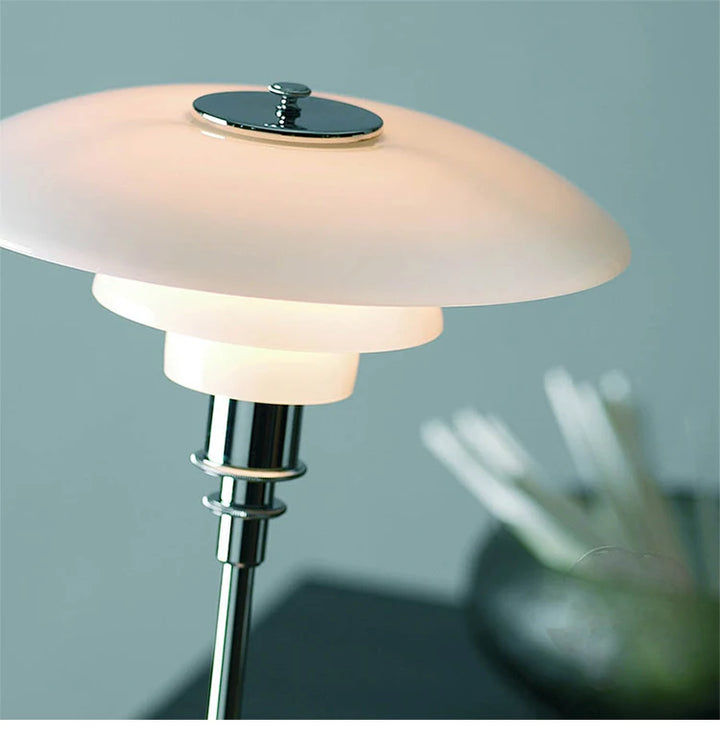 Modern table lamp with a white glass shade and chrome base on a blurred background