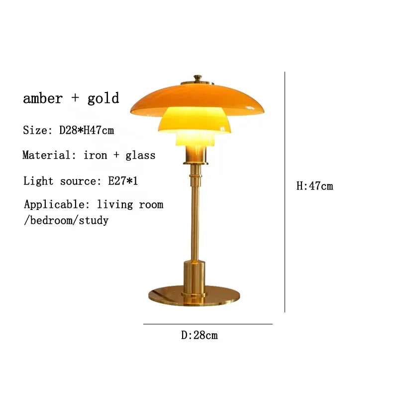 Table lamp with amber glass shade and gold base on a white background