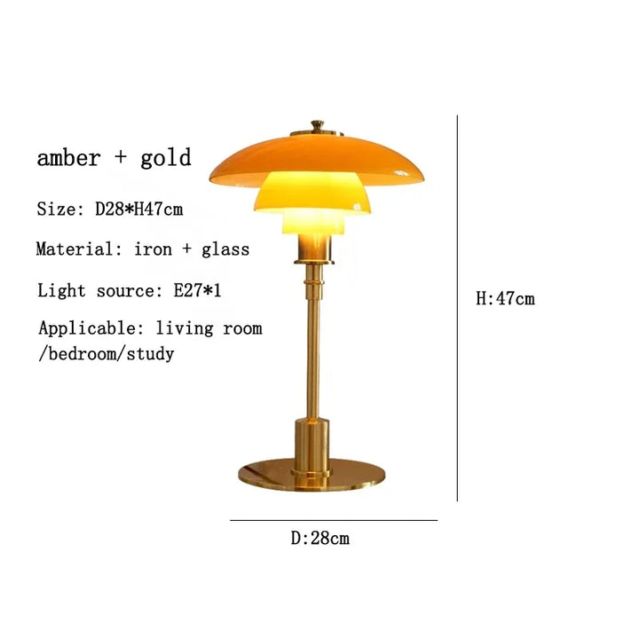 Table lamp with amber glass shade and gold base on a white background