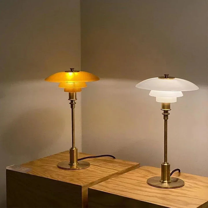 Two table lamps on a wooden surface with a neutral background