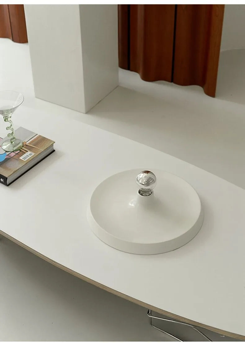 White ceiling lamp with a transparent bulb on a white surface
