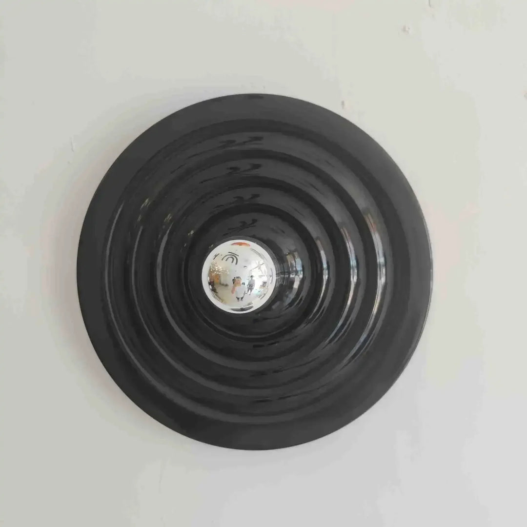 Black circular light fixture on a white ceiling