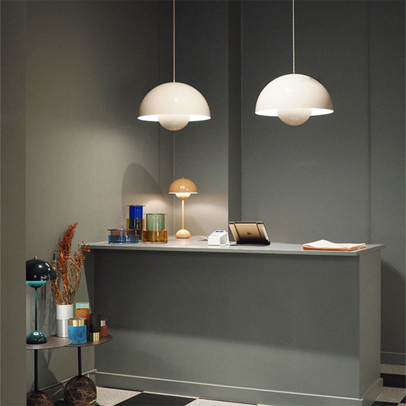 Pendant lamps with a reception desk and decorative items against a gray wall.