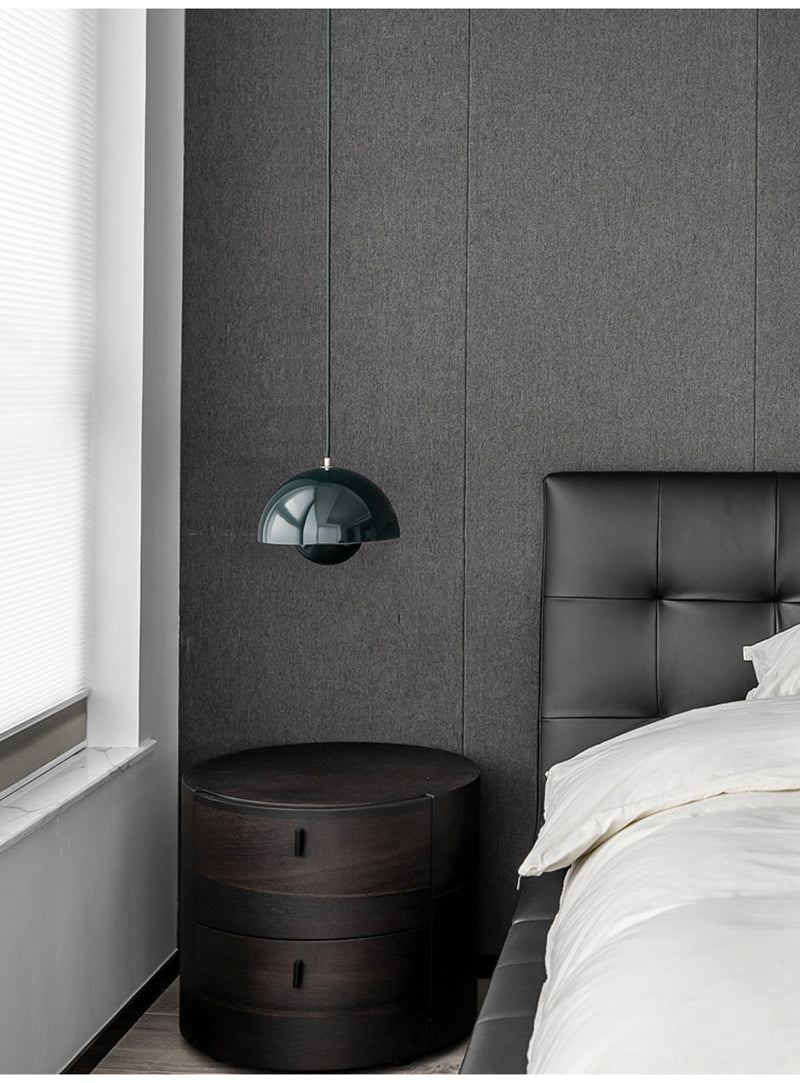 Modern bedroom with dark gray wall, green pendant lamp, and white bedding.