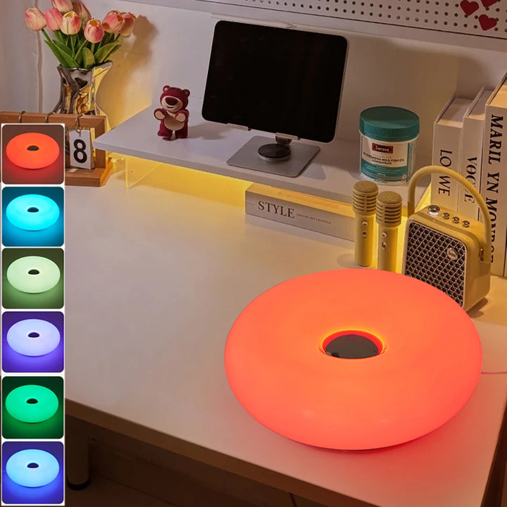 Color-changing LED strip light on a desk with a monitor and decor items.