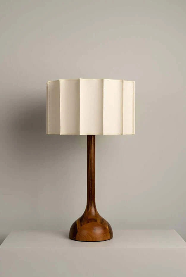 Table lamp with wooden base and white shade on a neutral background