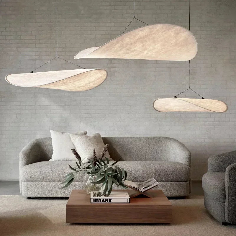 Modern living room with gray sofa, wooden coffee table, and pendant lights.