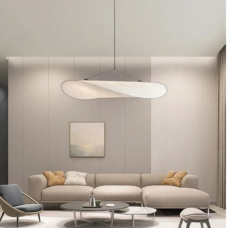 Modern living room with a beige sectional sofa, coffee table, and pendant light.