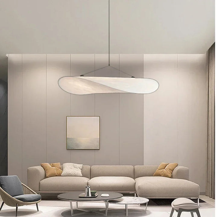 Modern living room with a beige sectional sofa, coffee table, and pendant light.