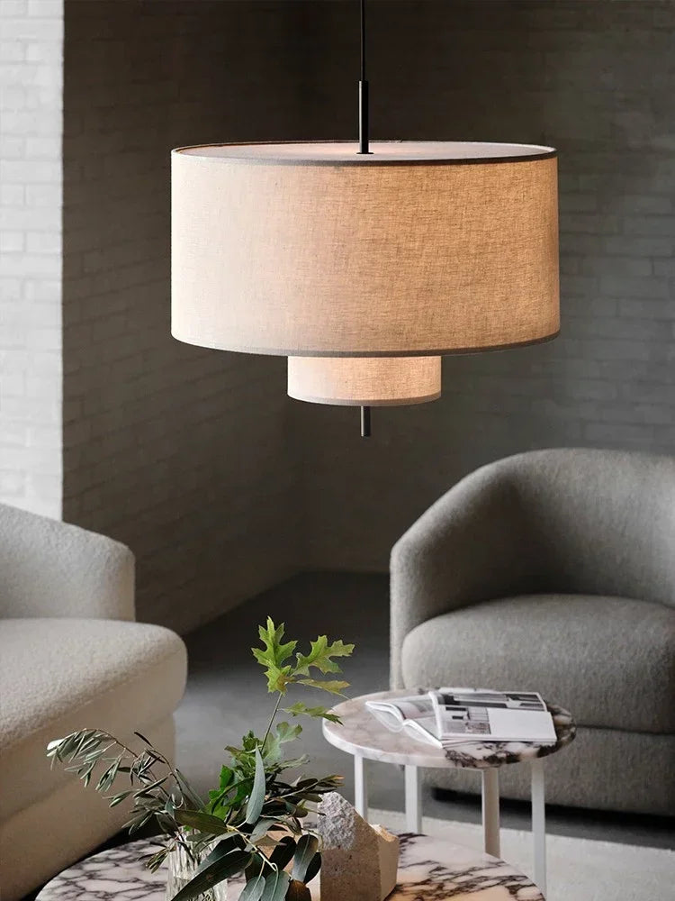 Modern living room with a pendant lamp, gray chairs, and a small round table.