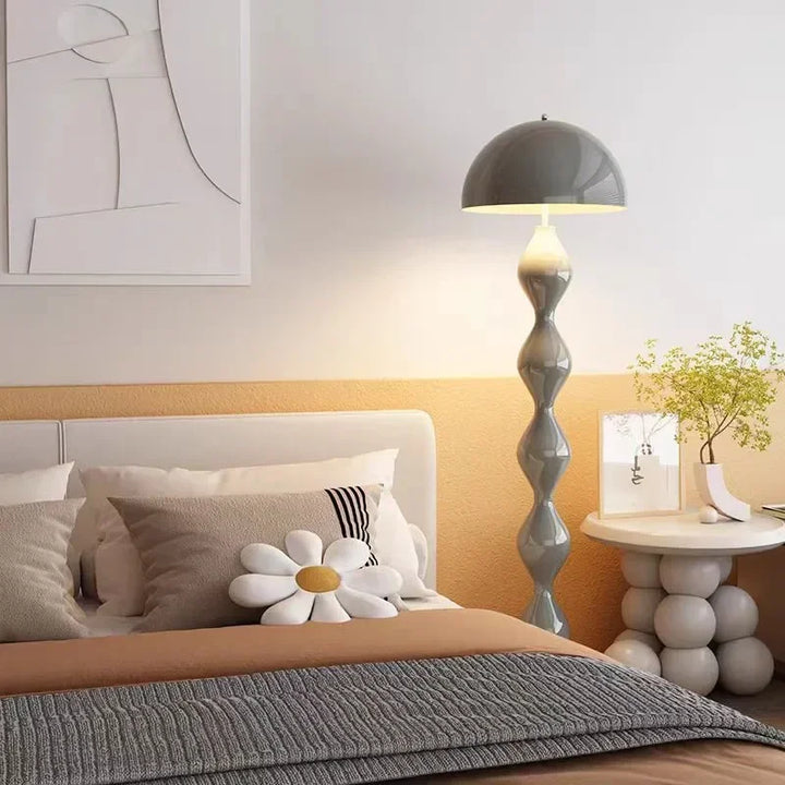 Modern bedroom with a bed, lamp, and decorative items.
