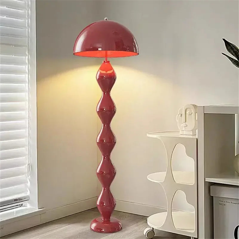 Red floor lamp in a room with a window and white shelves.