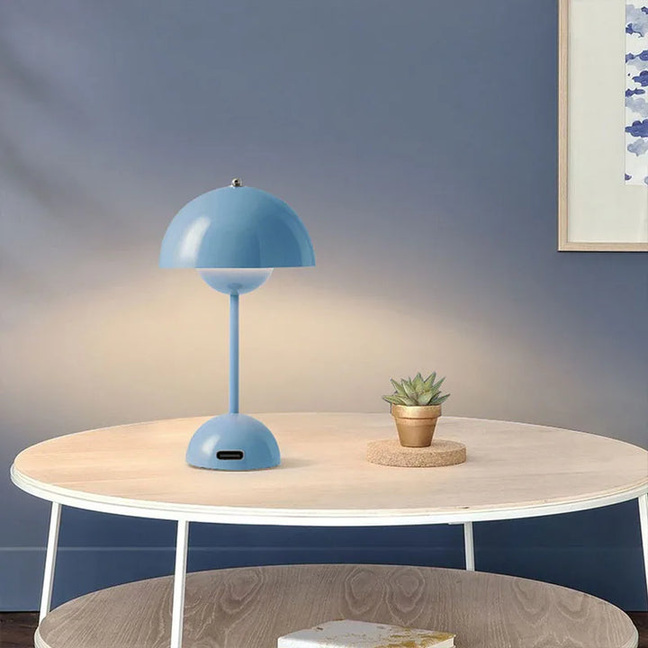 Blue lamp on a wooden table against a blue wall