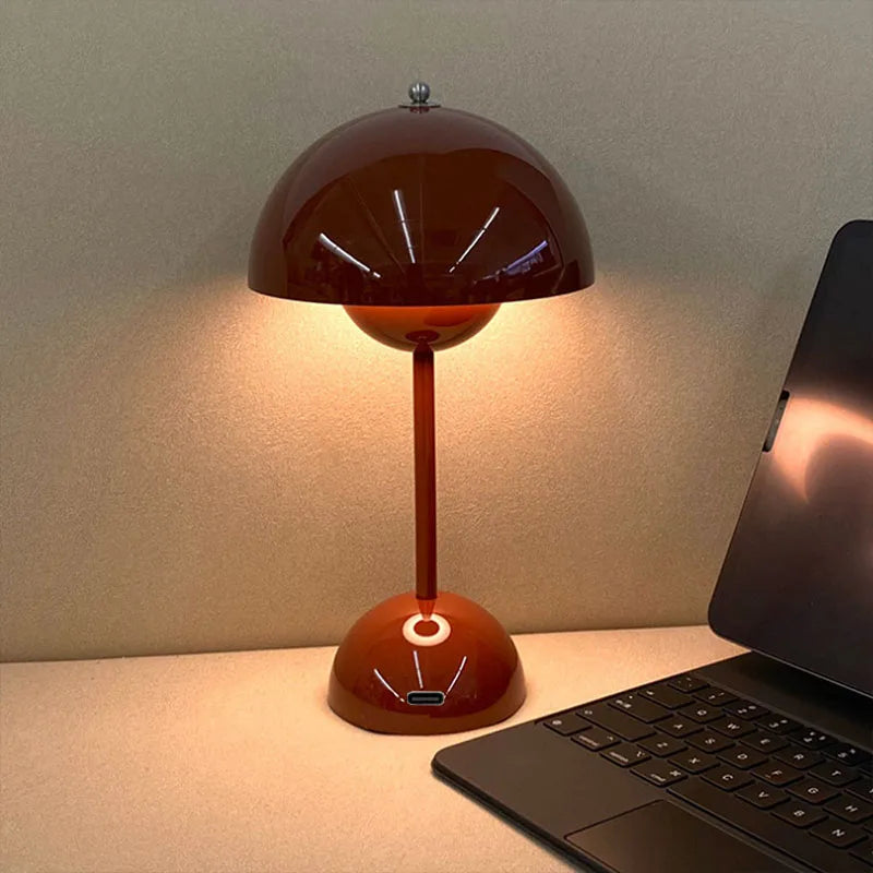 Vintage-style red table lamp on a desk next to a laptop