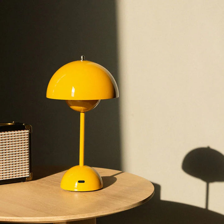 Yellow table lamp on a wooden surface with a dark wall and light floor in the background