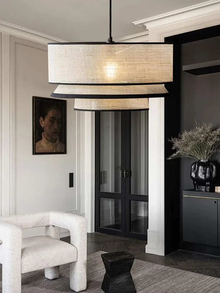 Modern interior with a large pendant light, white armchair, and black door.