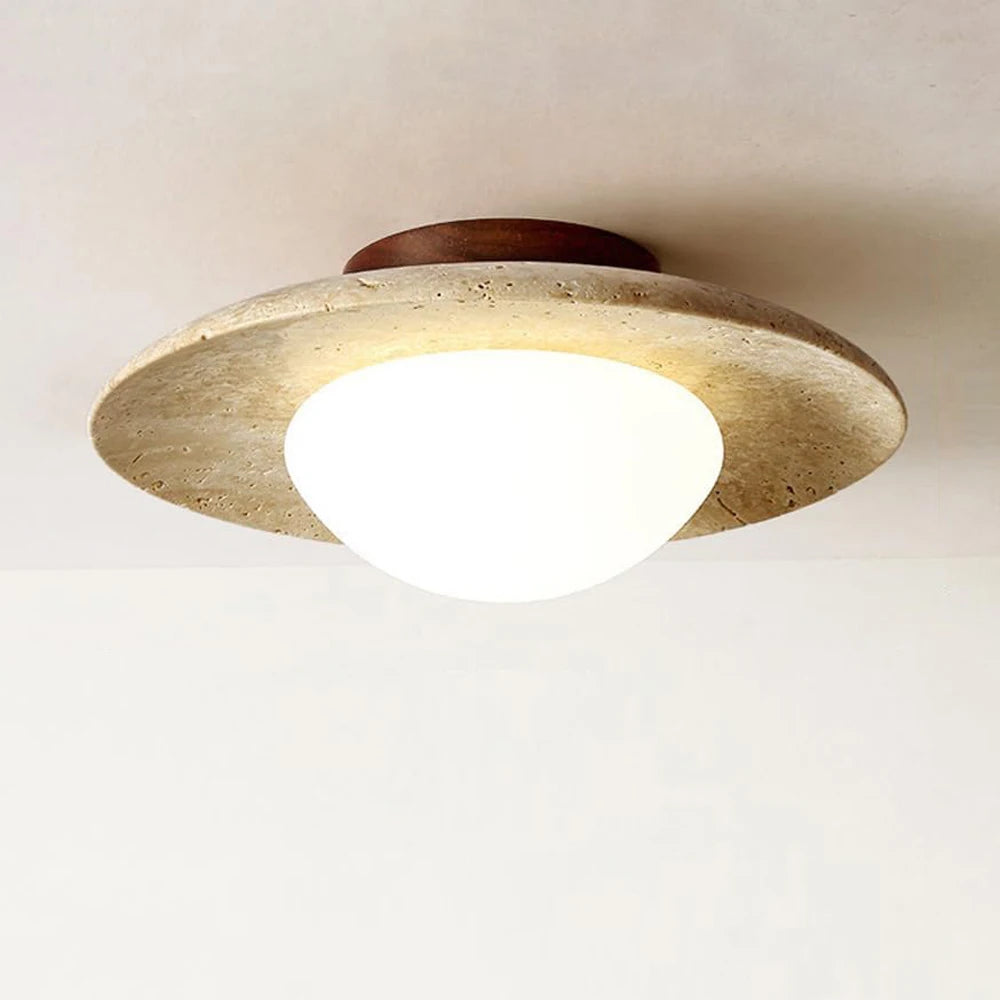 Ceiling light fixture with a stone-like finish on a plain background