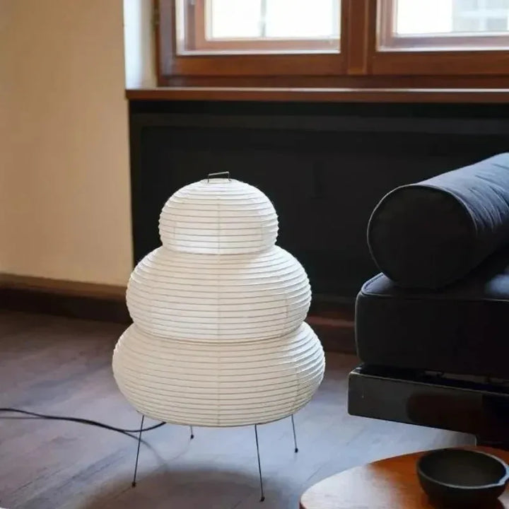White textured floor lamp in a room with a sofa and windows.