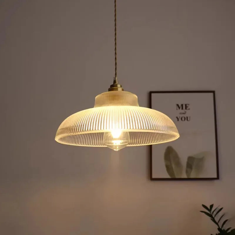 Glass pendant light fixture with a blurred background featuring a framed picture.
