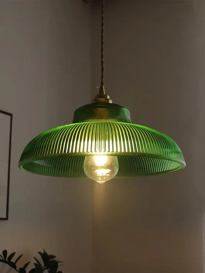 Green pendant light with a visible bulb against a neutral background
